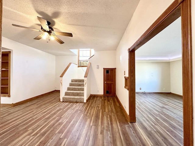 interior space featuring a textured ceiling, wood-type flooring, and ceiling fan