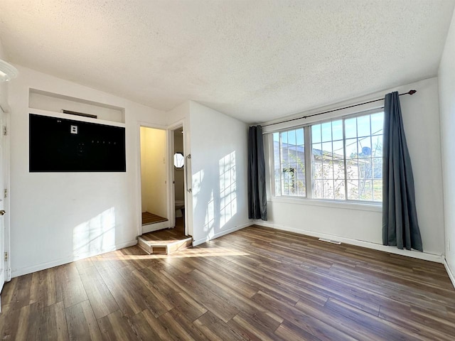 interior space featuring a textured ceiling and dark wood-type flooring