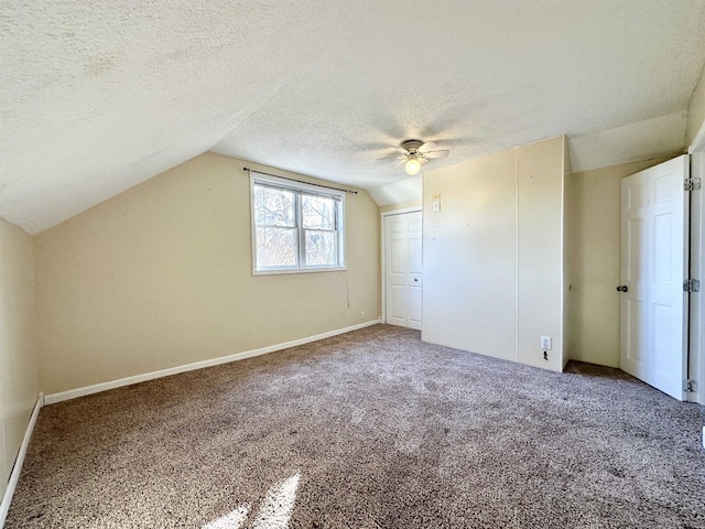 bonus room featuring ceiling fan, a textured ceiling, vaulted ceiling, and carpet floors