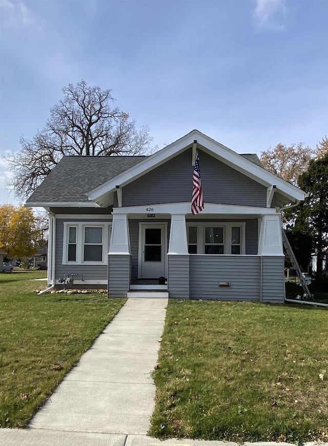 view of front of house featuring covered porch and a front yard