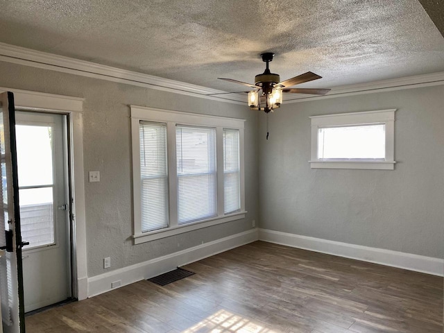 spare room featuring a textured ceiling, ceiling fan, plenty of natural light, and dark wood-type flooring