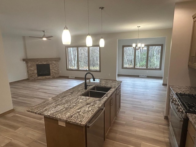 kitchen featuring light hardwood / wood-style flooring, plenty of natural light, and a kitchen island with sink