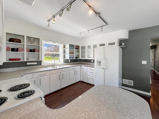 kitchen with white appliances, dark hardwood / wood-style flooring, sink, and white cabinets