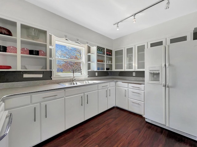 kitchen with rail lighting, dark hardwood / wood-style flooring, white cabinetry, sink, and white refrigerator with ice dispenser