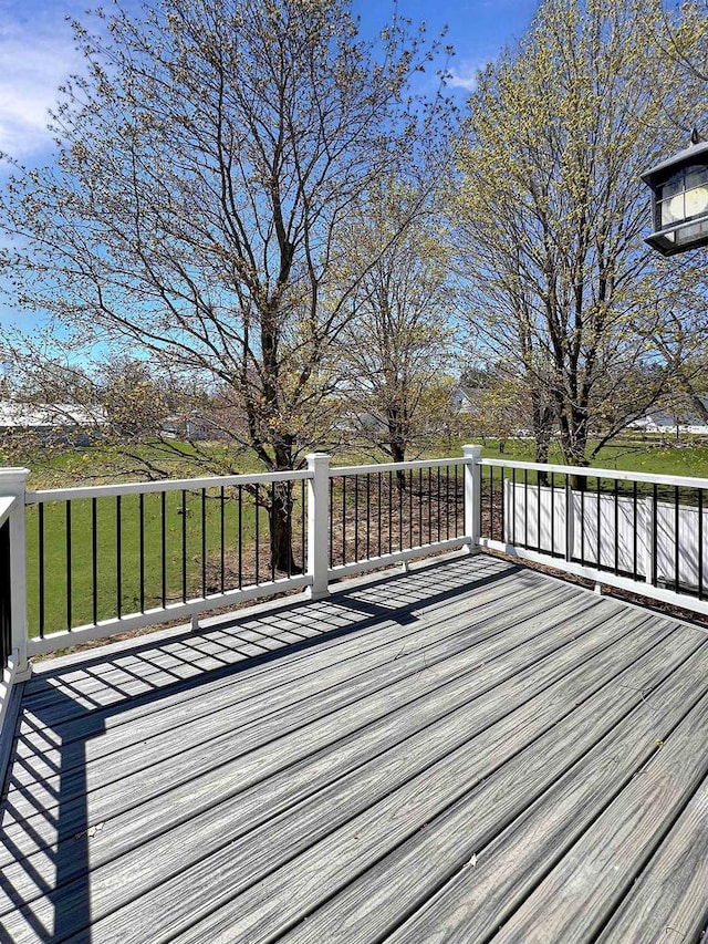 wooden terrace featuring a lawn