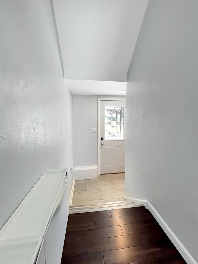 doorway with vaulted ceiling and light hardwood / wood-style flooring