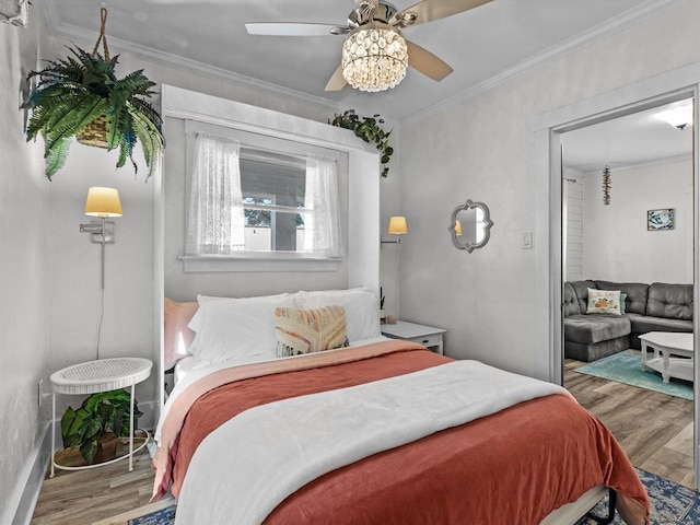 bedroom featuring hardwood / wood-style floors, crown molding, and ceiling fan