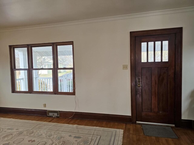 entrance foyer with crown molding and dark hardwood / wood-style flooring