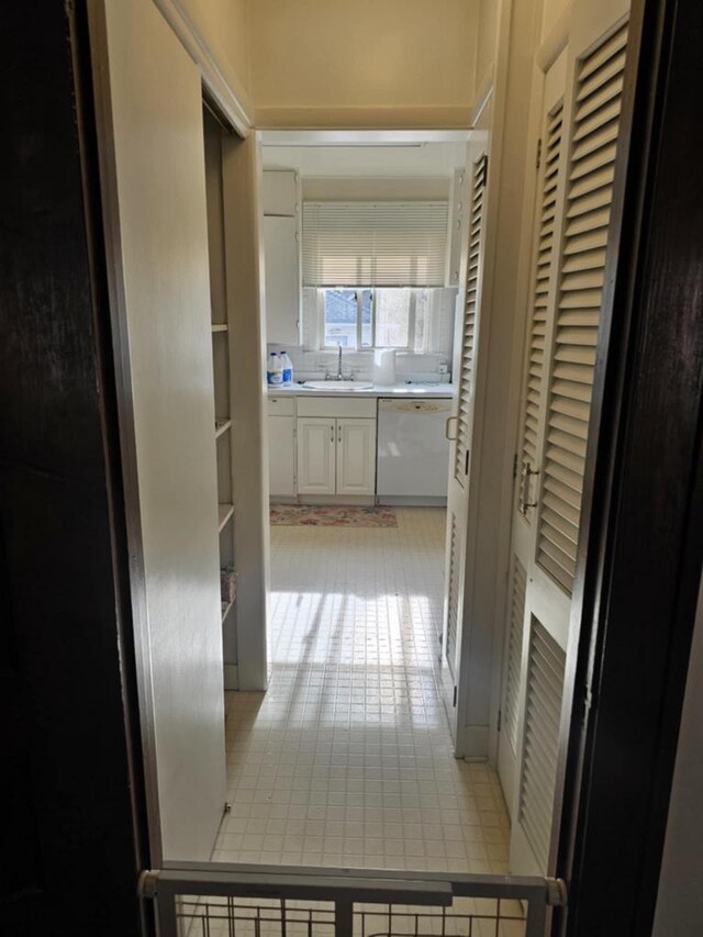 corridor featuring sink and light tile patterned floors