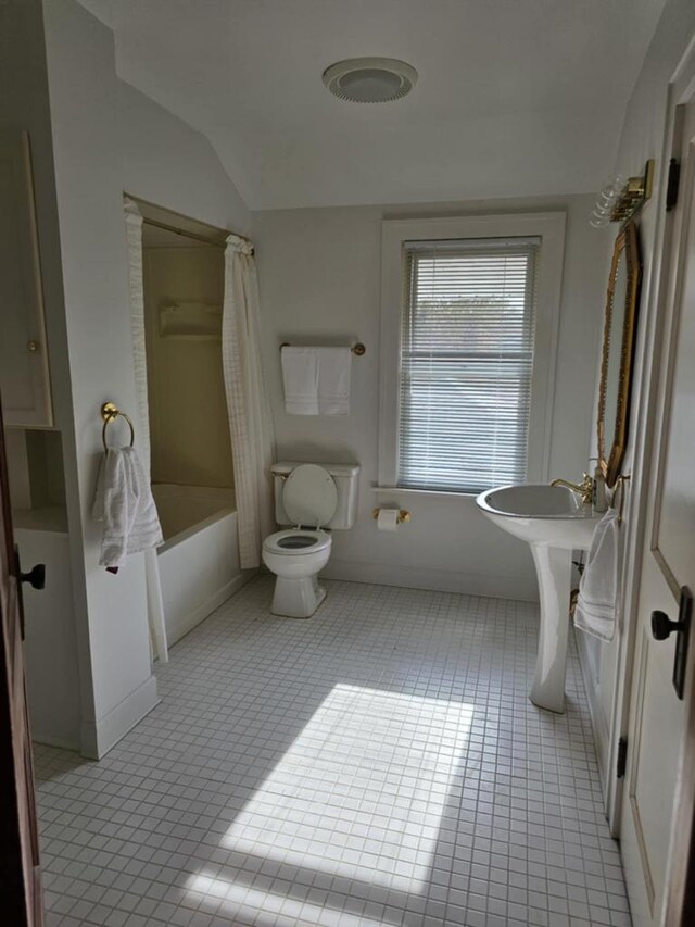 bathroom featuring toilet, tile patterned floors, lofted ceiling, and shower / tub combo