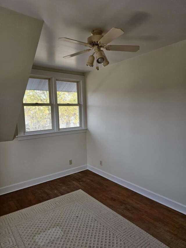 empty room with ceiling fan and dark hardwood / wood-style flooring