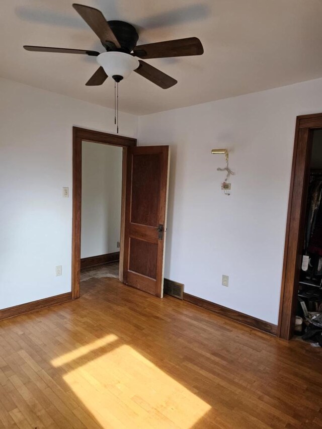 empty room with hardwood / wood-style flooring and ceiling fan