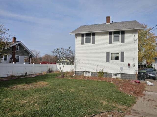 back of house featuring a lawn