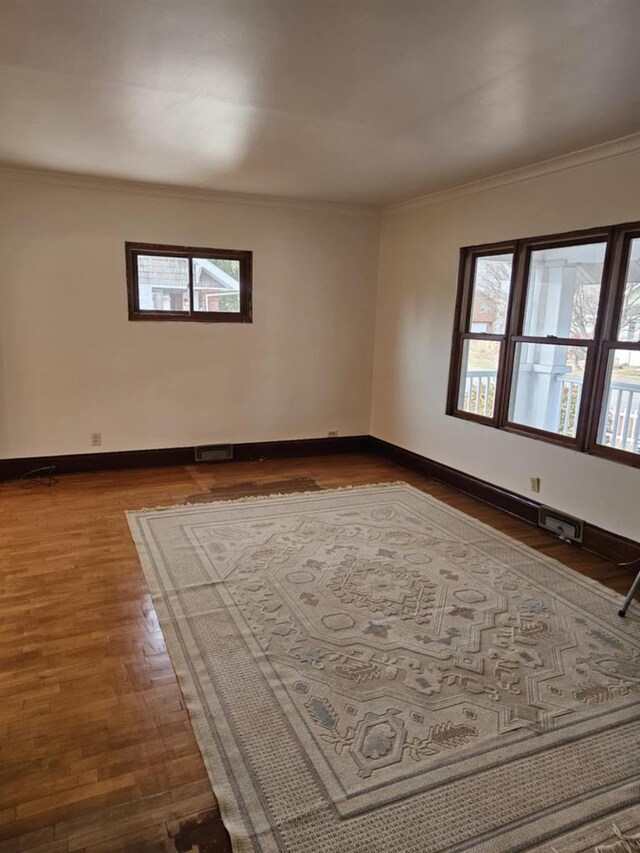 empty room with crown molding and hardwood / wood-style flooring