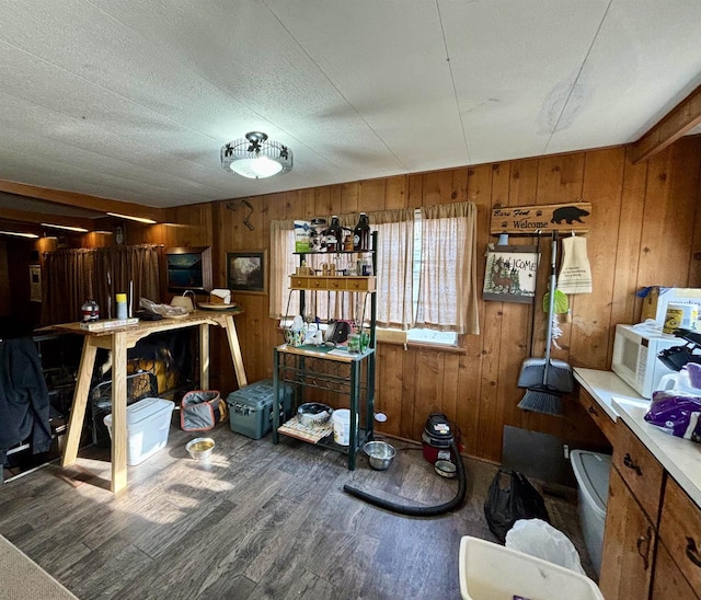 miscellaneous room with wood-type flooring, a textured ceiling, and wood walls