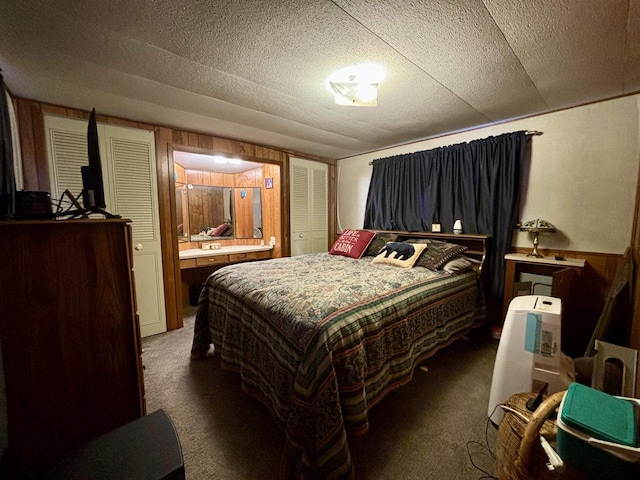 bedroom with a closet, dark carpet, and a textured ceiling