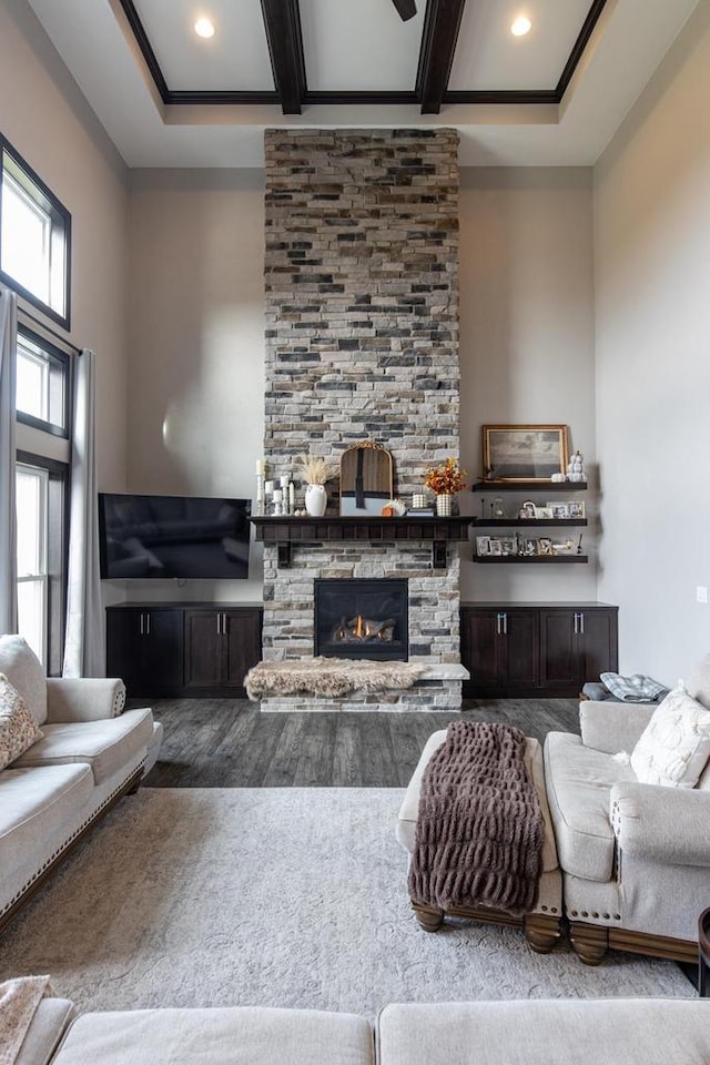 living room featuring a fireplace, a high ceiling, and beam ceiling