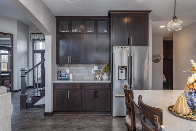 kitchen featuring high quality fridge, dark hardwood / wood-style floors, backsplash, dark brown cabinets, and pendant lighting