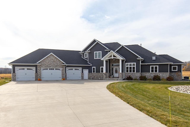 craftsman house with a garage and a front lawn