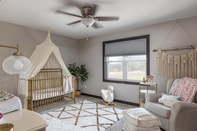 bedroom with carpet, a nursery area, and ceiling fan