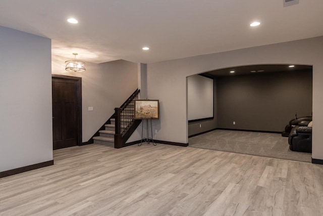 unfurnished room with a chandelier and light wood-type flooring