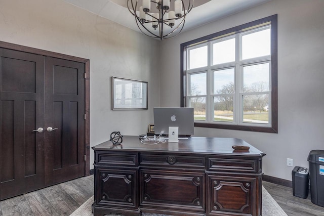 office space with plenty of natural light, a notable chandelier, and light hardwood / wood-style flooring