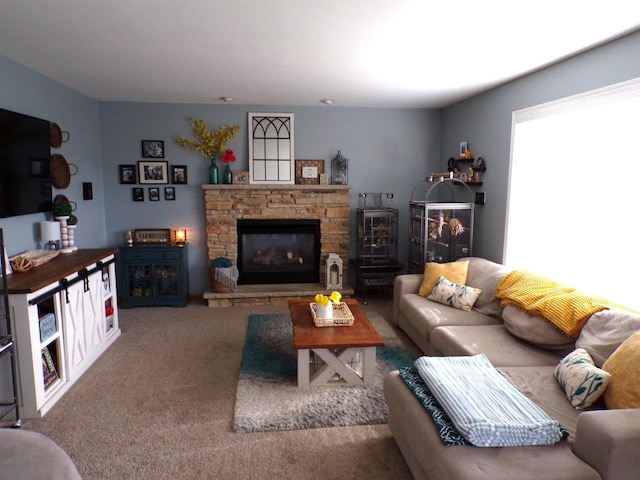 carpeted living room featuring a stone fireplace