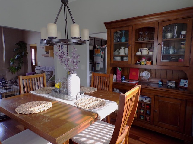 dining space featuring dark wood-type flooring and an inviting chandelier