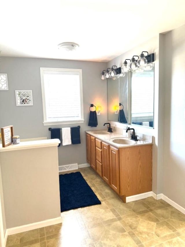 N4266 Cherokee Ct, Markesan, WI 53946 - bathroom featuring double vanity, baseboards, and tile patterned flooring
