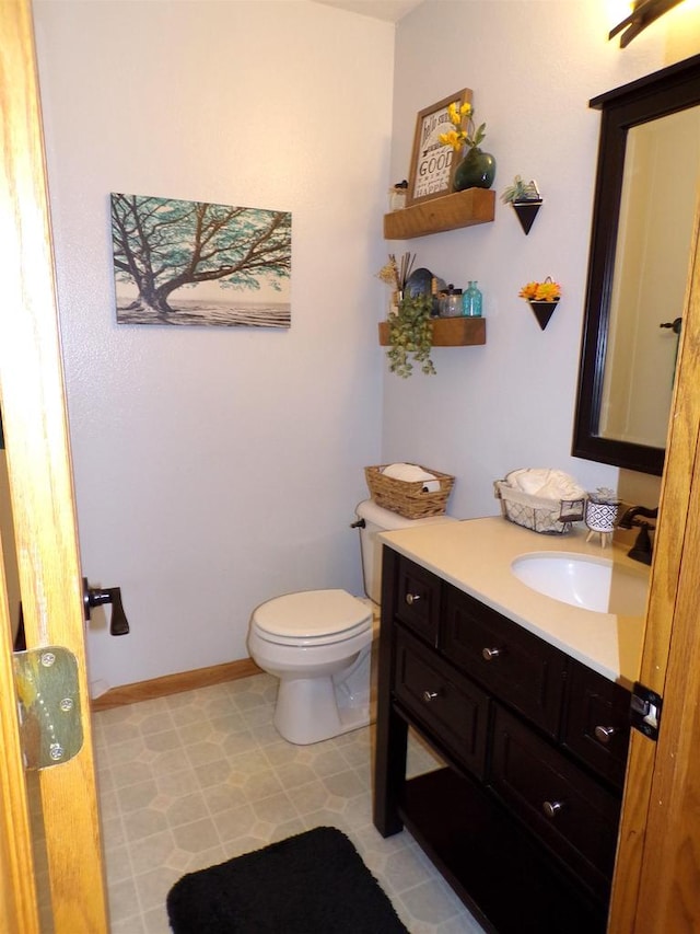 bathroom featuring toilet, vanity, and tile patterned flooring