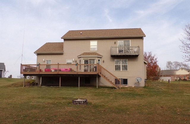 back of property with a wooden deck, a yard, and a fire pit