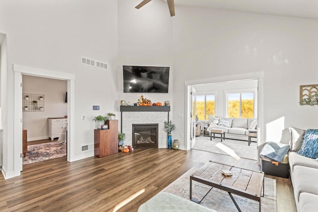 living room with beamed ceiling, hardwood / wood-style floors, high vaulted ceiling, and ceiling fan