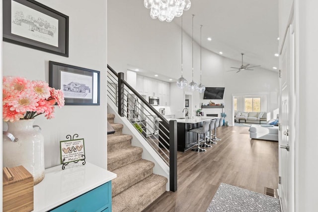 6558 Vista Vly Unit 1, Windsor, WI 53598 - staircase with high vaulted ceiling, a ceiling fan, wood finished floors, recessed lighting, and a chandelier