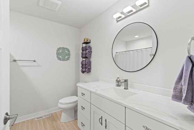 bathroom featuring toilet, hardwood / wood-style flooring, and vanity