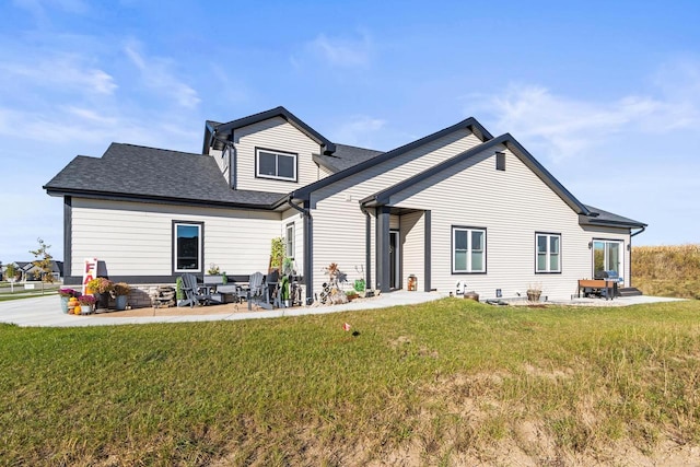 back of house with a patio and a lawn