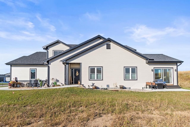 rear view of property with a patio and a lawn