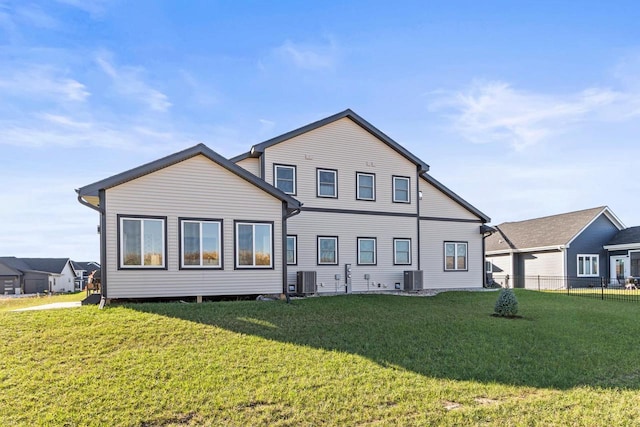 rear view of property with cooling unit and a lawn