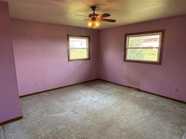 carpeted spare room featuring ceiling fan