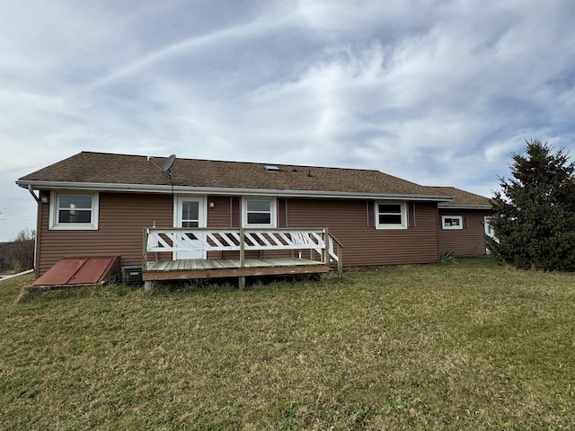 rear view of house featuring a deck and a lawn