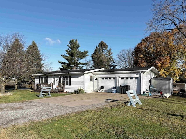 view of front of home featuring a garage, a front lawn, and a deck