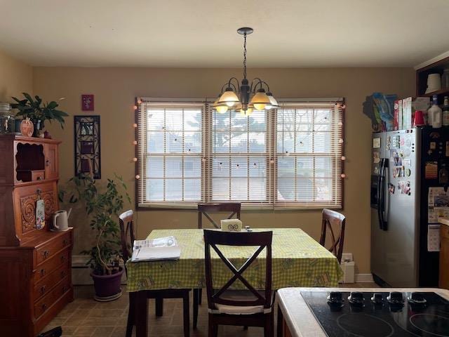 dining area featuring a healthy amount of sunlight and a notable chandelier