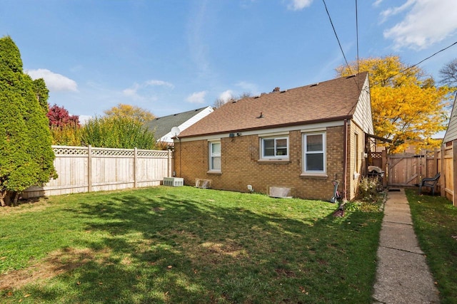 back of house with a yard and central AC unit