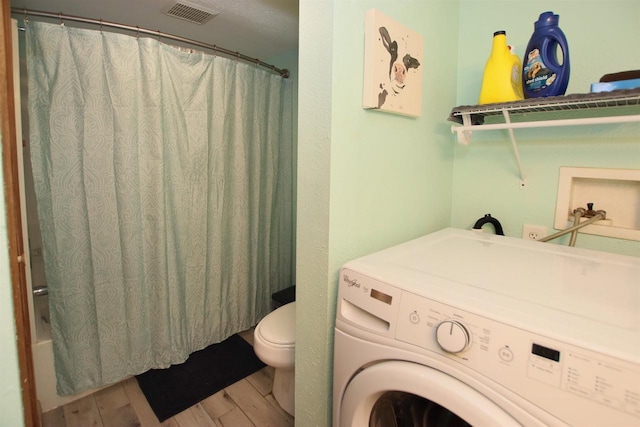 laundry area featuring wood-type flooring and washer / dryer