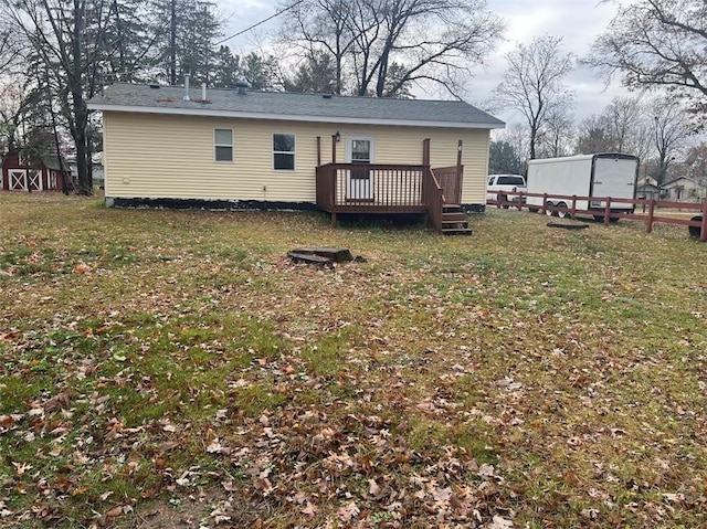 back of house featuring a lawn and a deck