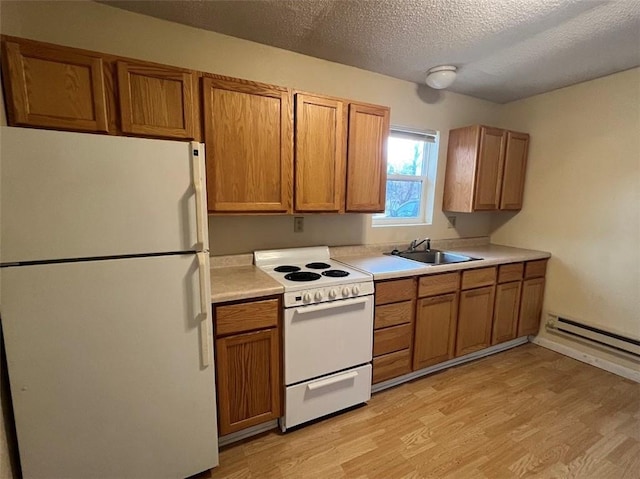 kitchen featuring sink, baseboard heating, a textured ceiling, white appliances, and light hardwood / wood-style flooring