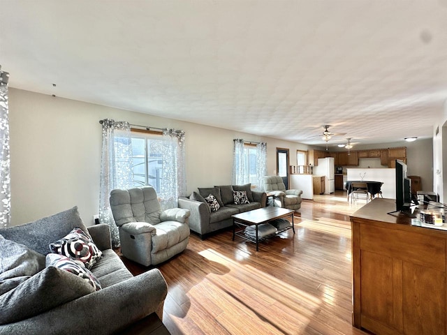 living room featuring light wood-type flooring and ceiling fan