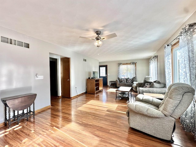 living room with wood-type flooring and ceiling fan