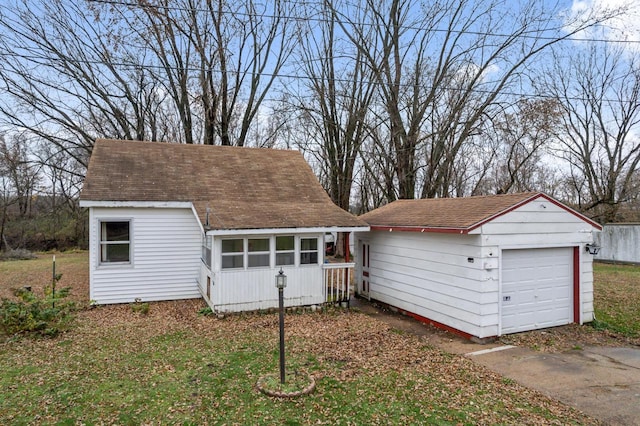 view of front of home featuring a sunroom and an outdoor structure