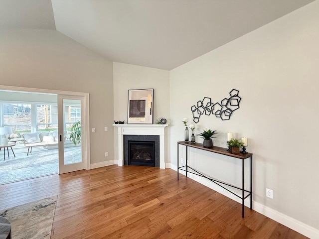 unfurnished living room with hardwood / wood-style floors and vaulted ceiling