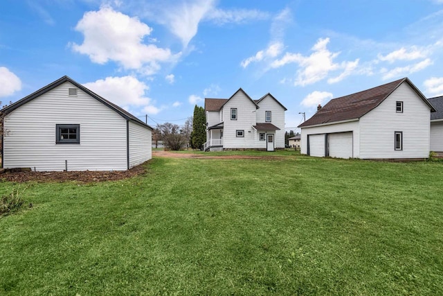 view of yard with a garage and an outbuilding